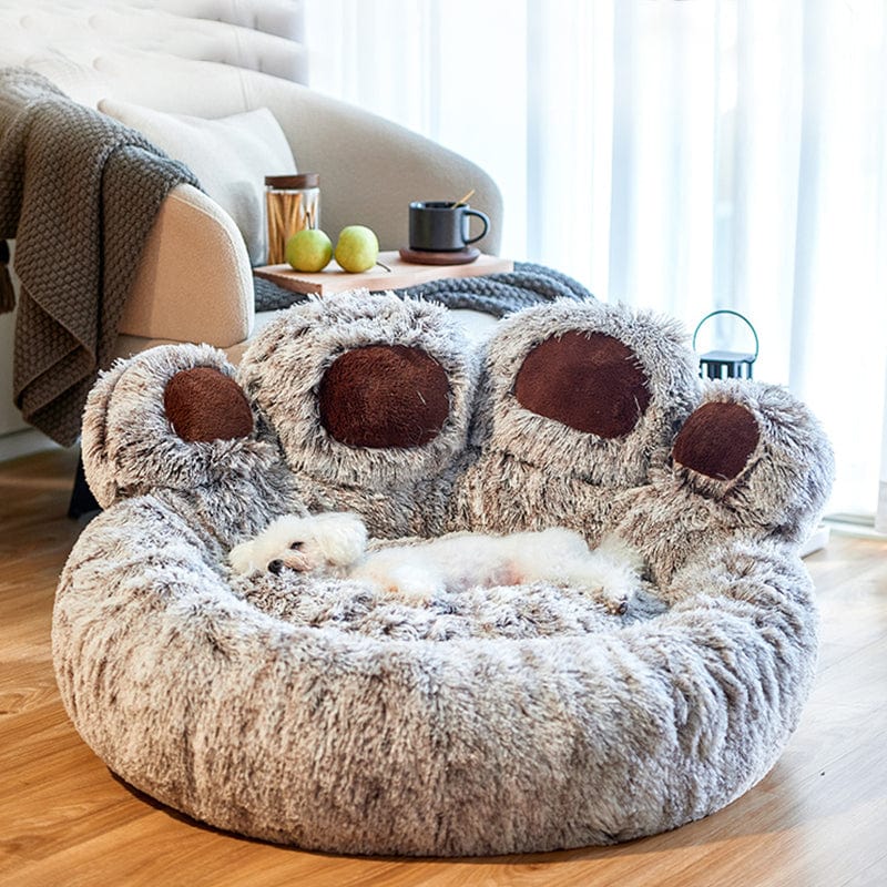 Een hond ligt vredig in een pootvormig orthopedisch bed, met de nadruk op het unieke ontwerp en comfort voor huisdieren