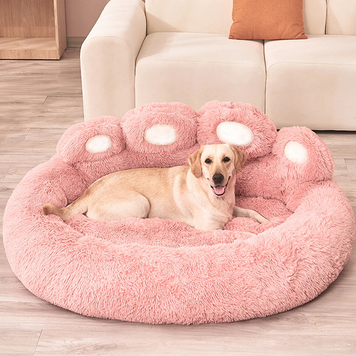 Een hond die comfortabel uitrust in een roze orthopedisch hondenbed in de vorm van een poot