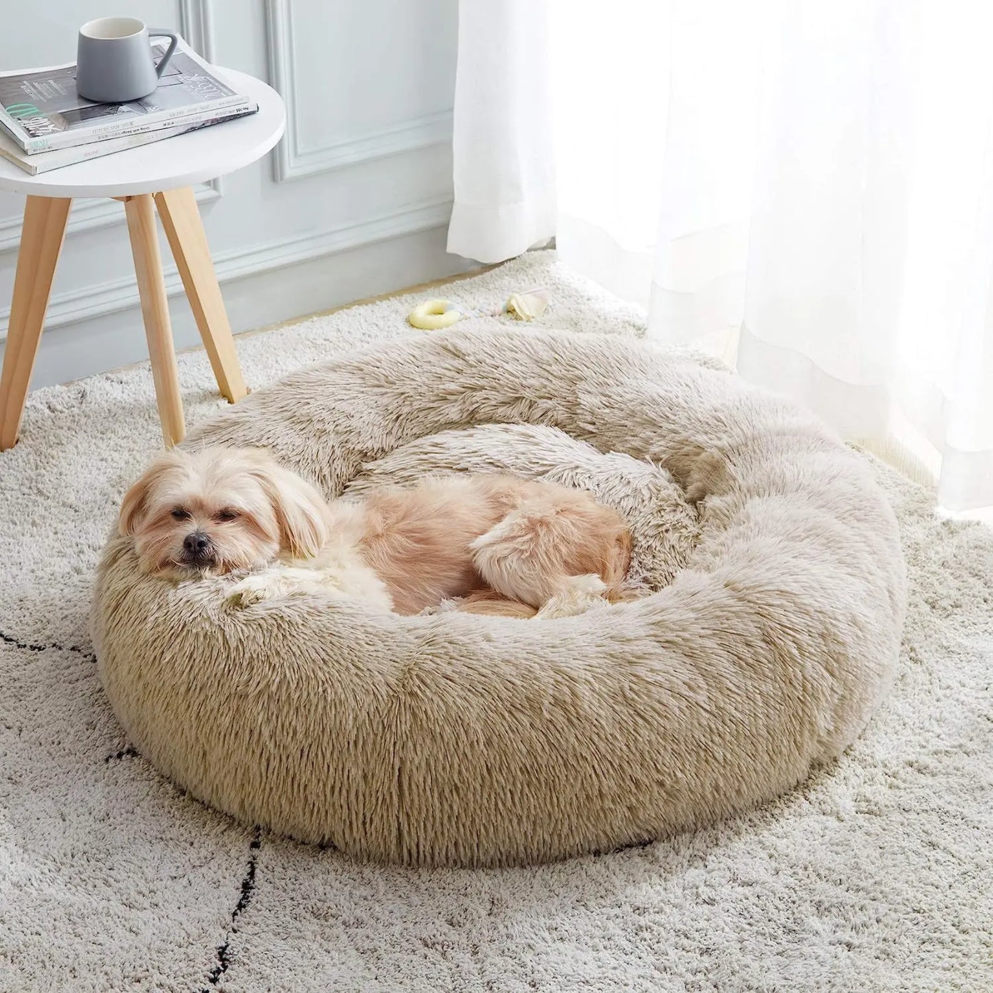 Een hond rust comfortabel uit in een rond Unopets honden- en kattenbed.