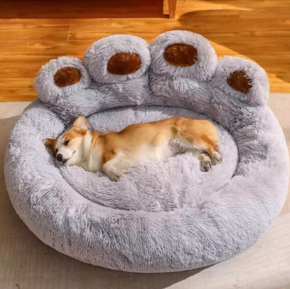 Een hond rust in een beige orthopedische hondenmand van Unopets in een woonkamer op een witte tapijt.