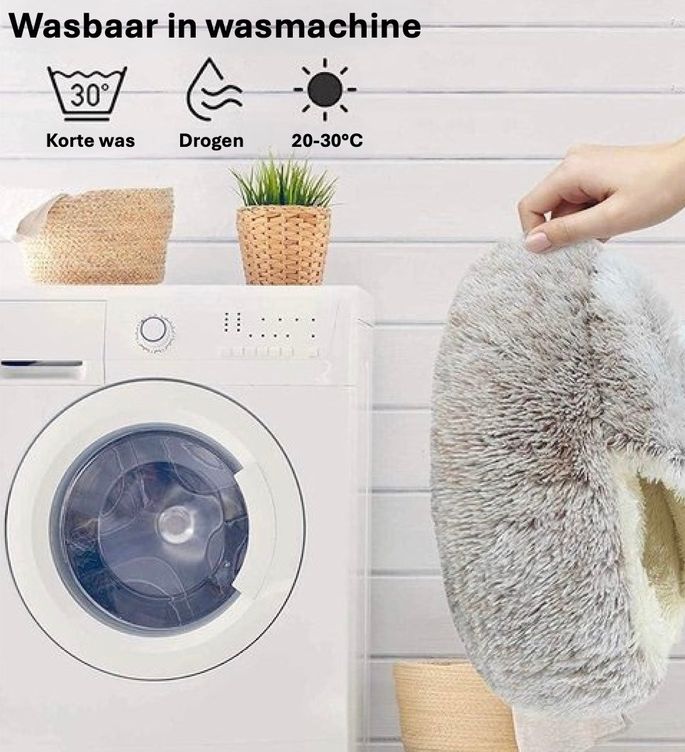 Een persoon toont het Unopets slaapnest bij een wasmachine, een pluche mand voor honden en katten.