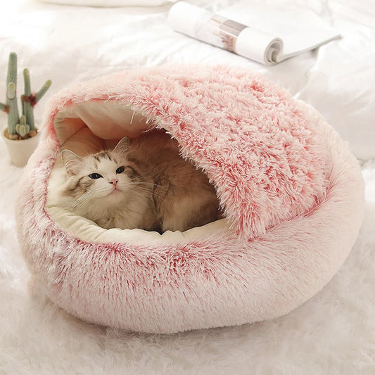Een kat opgekruld in een roze dierenbed, met het zachte pluche ontwerp van het Unopets Slaapnest voor huisdieren.