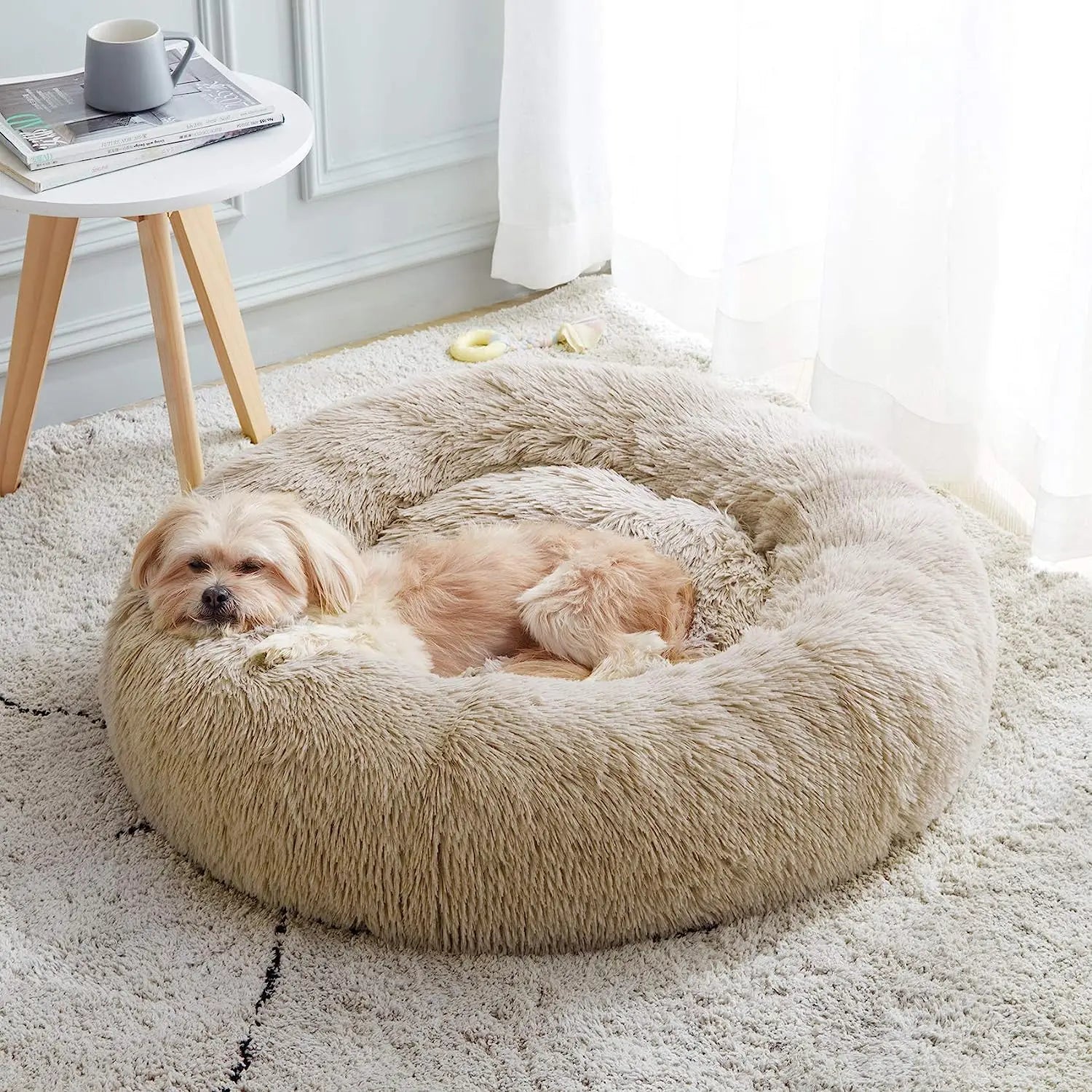 Een hond rust comfortabel uit in een rond Unopets honden- en kattenbed.